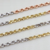 May include: Three gold rope chains, one in rose gold, one in yellow gold, and one in white gold. The chains are laid out on a white surface.