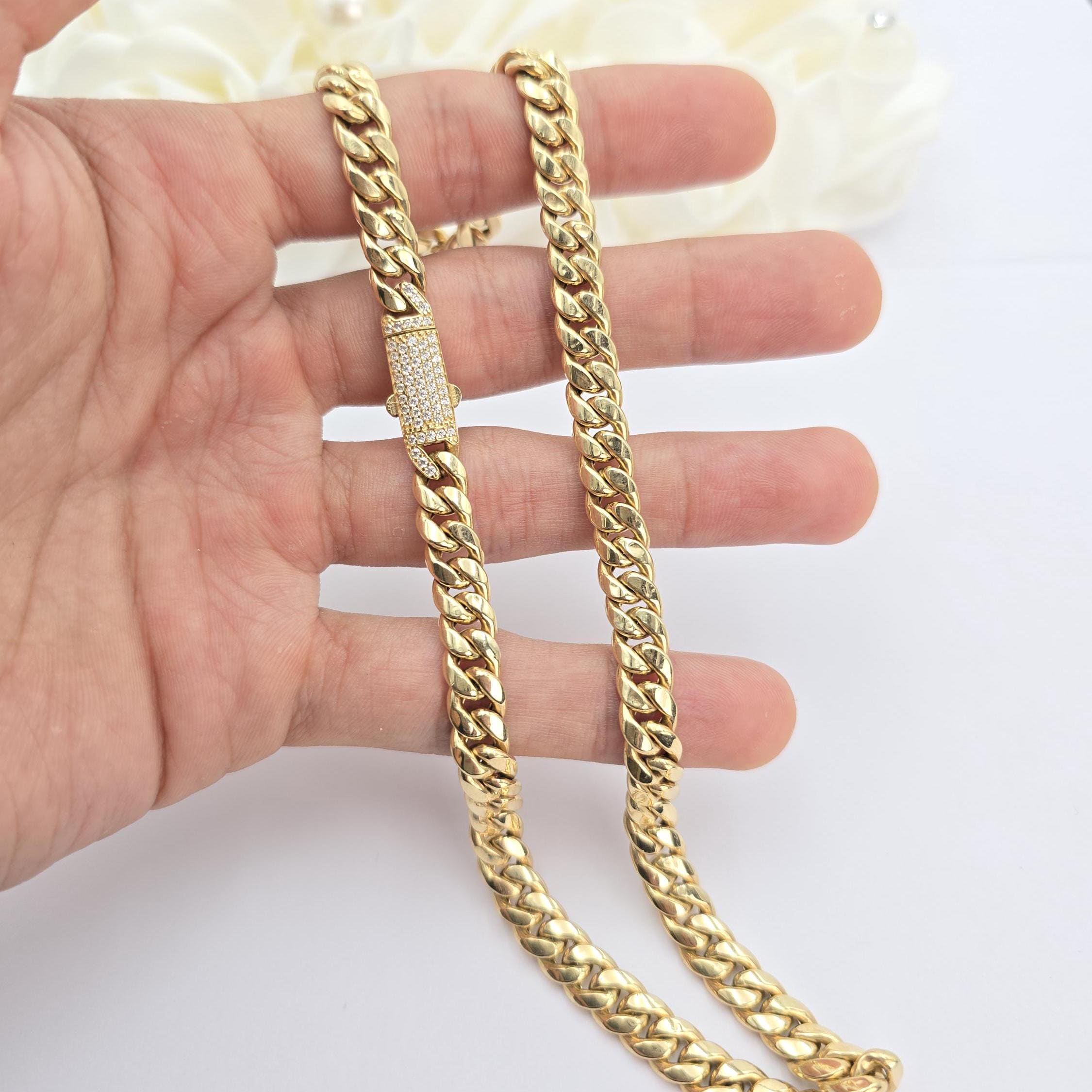 May include: A gold curb chain necklace with a diamond-encrusted clasp.