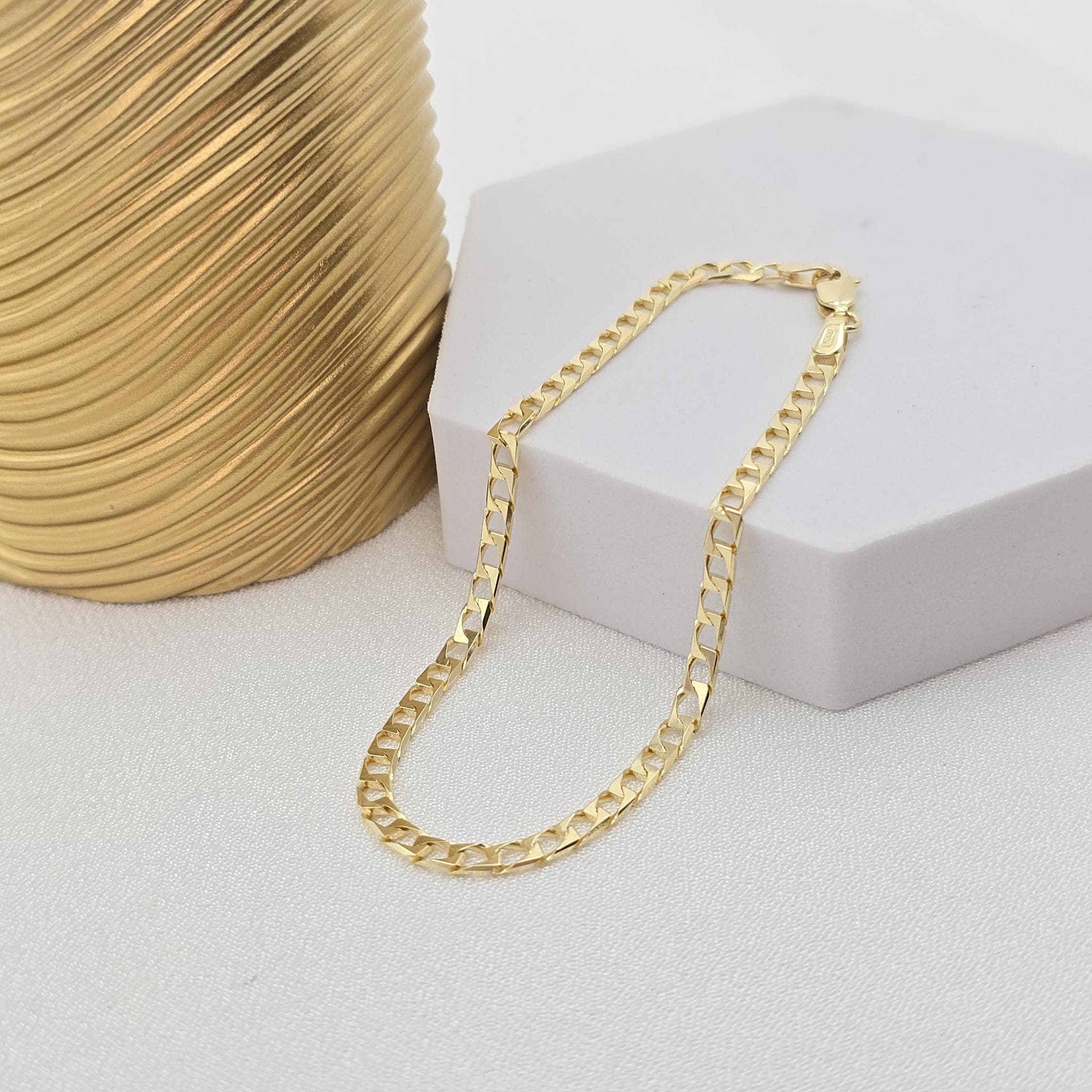 May include: A gold curb chain necklace with a lobster clasp closure.