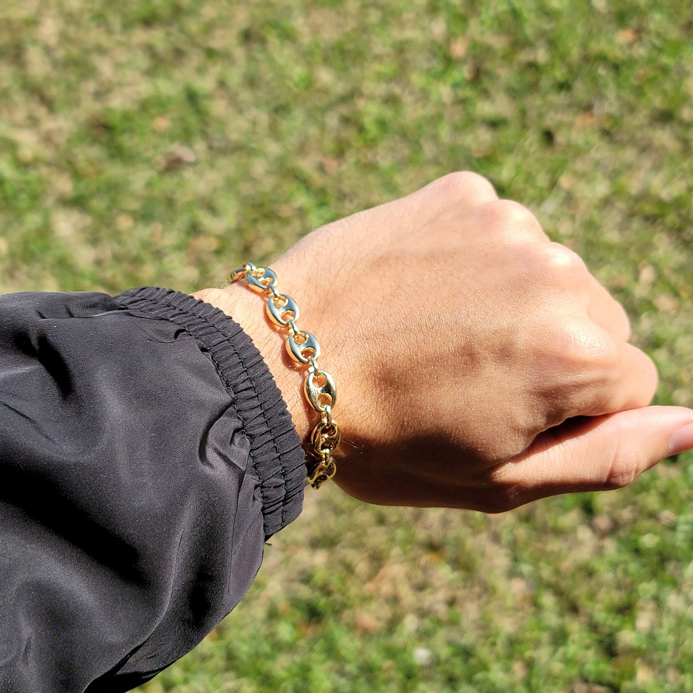 May include: A gold mariner chain bracelet.