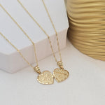 May include: Two gold heart-shaped necklaces with chains. One heart has the word &#39;MOM&#39; engraved on it and the other heart has the word &#39;DAD&#39; engraved on it.